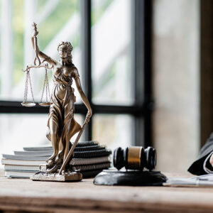 How a Violent Crime Criminal Lawyer Builds a Strong Defense, A statue of the goddess of justice is placed on the table in the judge's office, preserving law and justice. The concept of judging whether a legal matter is correct and fair.